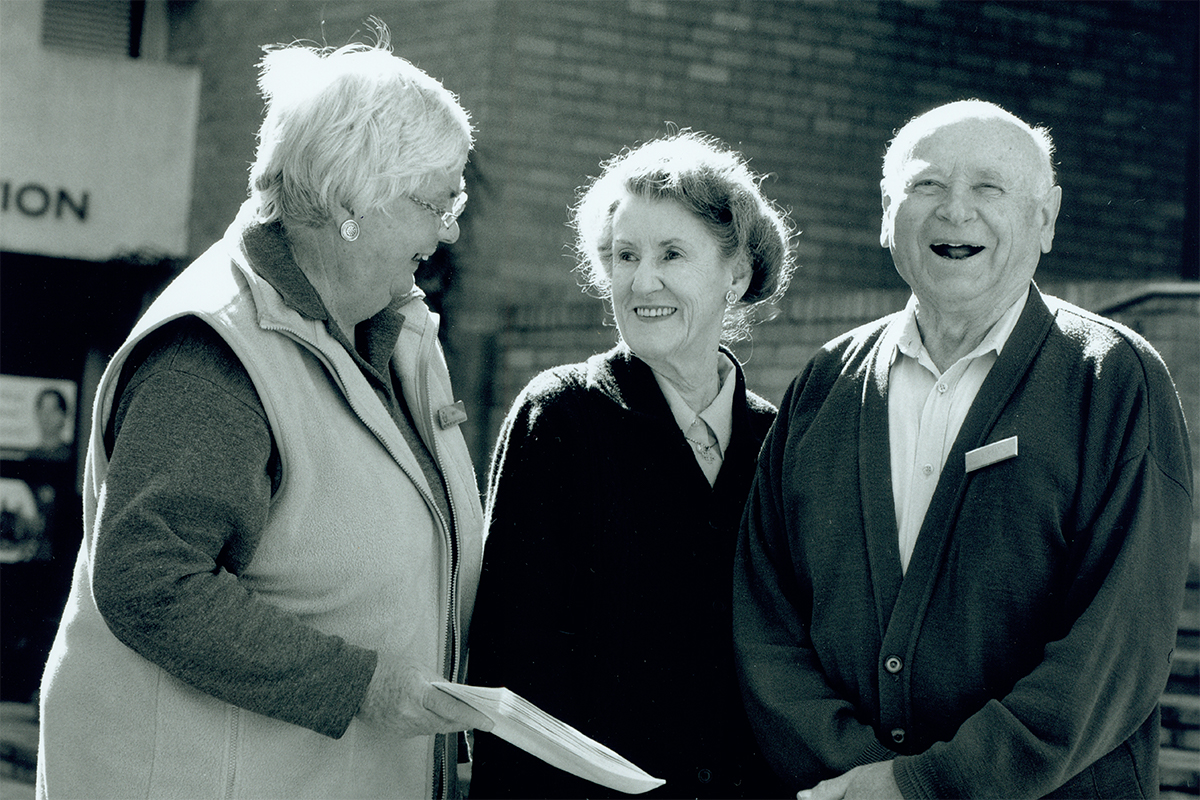 Two elderly women and an elderly man volunteering at Open Support